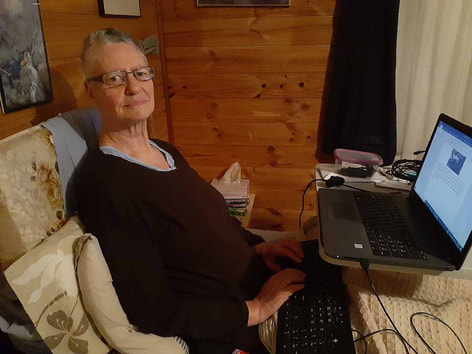 Picture of disabled writer Christine Grayden working in bed on her laptop using an AI writing program.